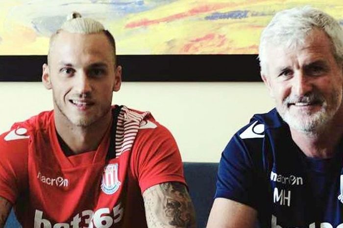 Pemain sayap Stoke, Marko Arnautovic (kiri), menandatangani kontrak didampingi pelatih Mark Hughes.