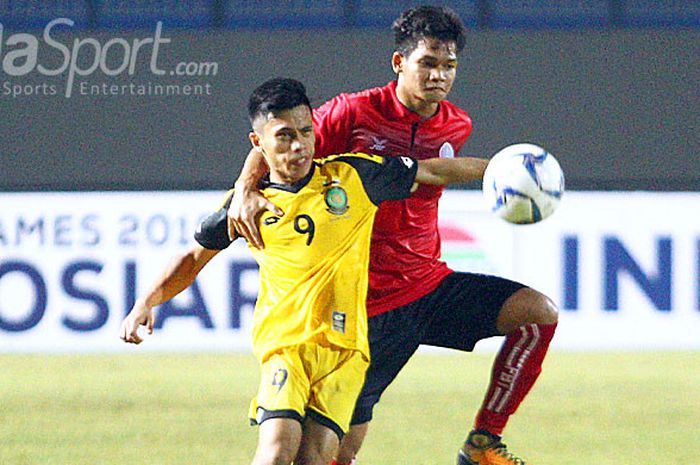Penyerang Brunei Darussalam, Mohammad Hanif Ainan (kuning) berusaha lepas dari kawalan pemain Kamboja pada laga Grup B Piala AFF U-19 2018 di Stadion Gelora Joko Samudro, Senin (2/7/2018).