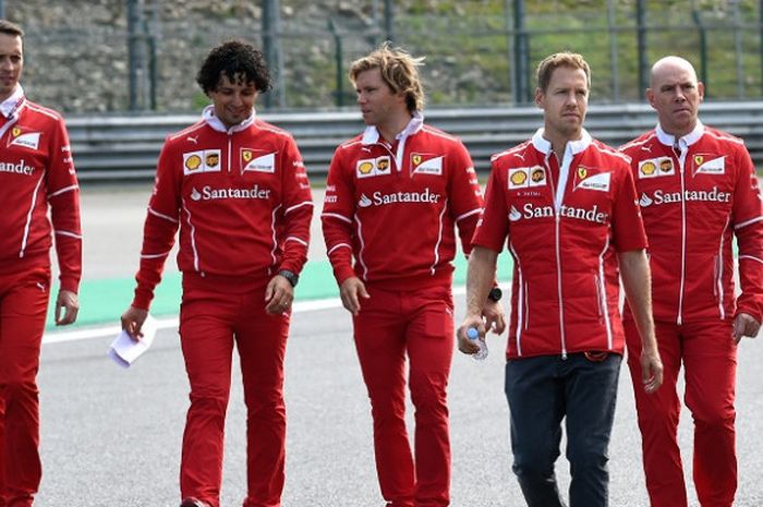 Pebalap Ferrari asal Jerman, Sebastian Vettel (kedua dari kanan) berjalan di lintasan Sirkuit Spa-Franchorchamps bersama tim, Kamis (24/8/2017).
