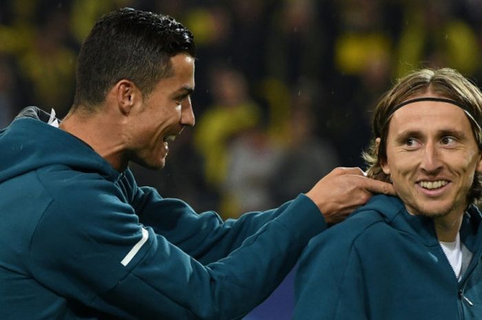 Mantan pemain Real Madrid, Cristiano Ronaldo (kiri), bercanda dengan rekannya, Luka Modric, sebelum dimulainya laga Grup H Liga Champions kontra Borussia Dortmund di Dortmund, Jerman pada 26 September 2017.       