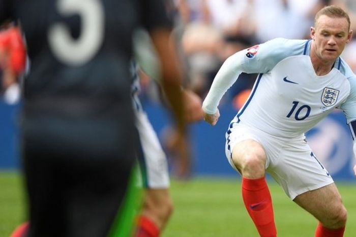 Kapten tim nasional Inggris, Wayne Rooney, menggiring bola dengan dada saat melawan Wales pada partai Piala Eropa Grup B di Stade Bollaert-Delelis, 16 Juni 2016.