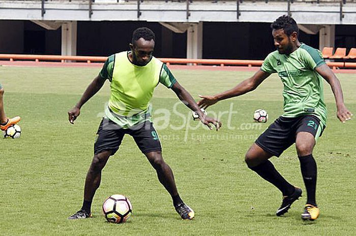 Dua pemain Persebaya, Ricky Kayame (kiri) berusaha melewati Fandli Imbiri pada sesi latihan gim di S