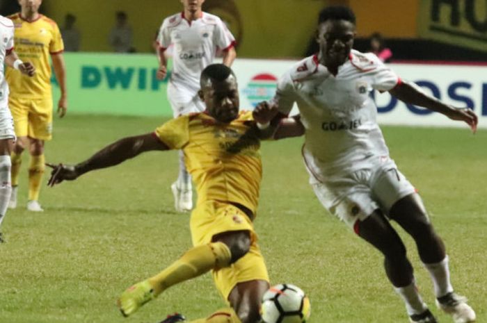 Penyerang Persija Jakarta, Osas Saha dijaga bek Sriwijaya FC, Marckho Sandi di Stadion Gelora Sriwij