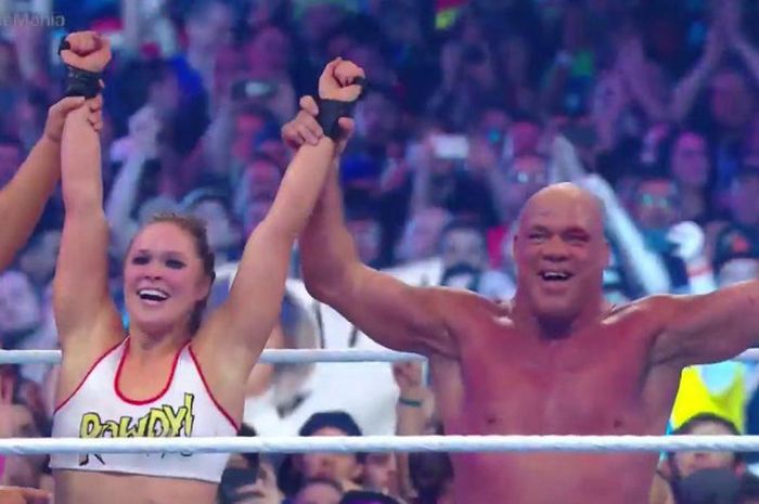 Selebrasi Ronda Rousey (kiri) dan Kurt Angle (kanan) saat memenangi laga pada ajang WrestleMania 34 yang digelar Minggu (8/4/2018).