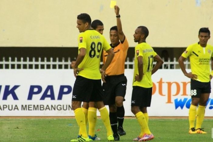 Bek asal Brasil milik Semen Padang, Cassio de Jesus dikartu kuning wasit Moch Adung saat dijamu Persipura di Stadion Mandala, Jayapura, Sabtu (17/9/2016). 