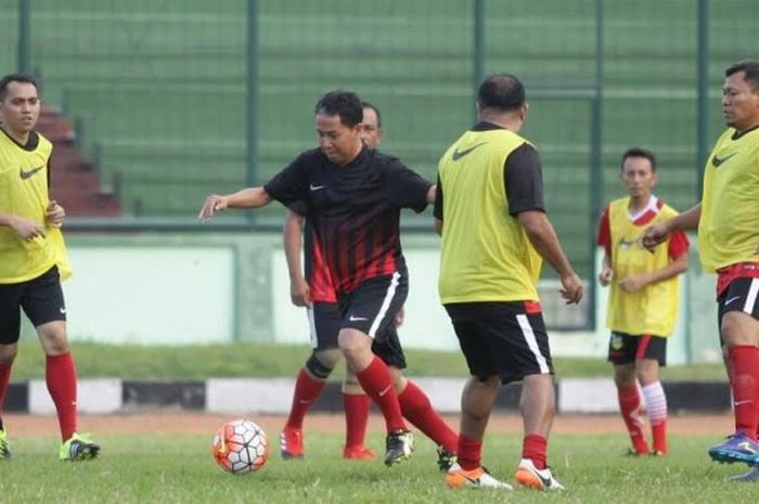 Wakil Ketua Umum PSSI, Joko Driyono (tengah) mencoba melewati pemain tim PT GTS dalam laga eksibisi di Stadion Siliwangi, Kota Bandung, Sabtu (7/1/2017) sore. 