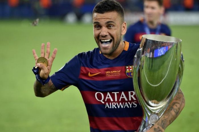 Dani Alves berpose dengan trofi juara Piala Super Eropa setelah FC Barcelona mengalahkan Sevilla di 