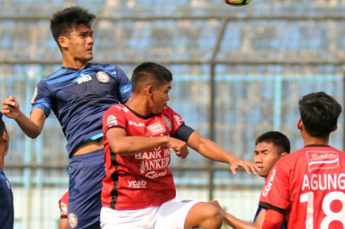 Pemain Arema FC U-19, M Rafli (melompat) sedang berduel dengan pemain Bali United U-19 dalam pertandingan di Stadion Kanjuruhan, Malang (16/9/2017).