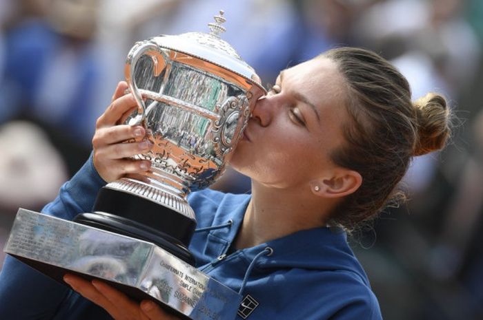 Ciuman pertama Simona Halep dengan trofi Grand Slam pertamanya yang diraih usai menjuarai ajang Roland Garros 2018, Sabtu (9/6/2018).