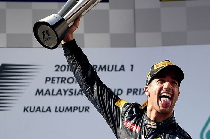 Pebalap Formula 1 (F1) yang membela Red Bull Racing, Daniel Ricciardo, melakukan seleberasi di atas podium setelah memenangi balapan GP Malaysia di Sirkuit Sepang, Minggu (2/10/2016).