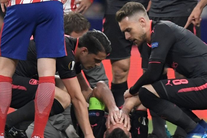Bek Arsenal, Laurent Koscielny, menahan rasa sakit karena mengalami cedera dalam laga leg kedua semifinal Liga Europa kontra Atletico Madrid di Stadion Wanda Metropolitano, Madrid, Spanyol pada 3 Mei 2018.