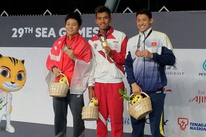 Perenang putra Indonesia, Triady Fauzi (tengah), berpose dengan medali emas yang didapat dari nomor 200 meter gaya ganti di National Aquatic Centre, KL Sports, Bukit Jalil, Kamis (24/8/2017).