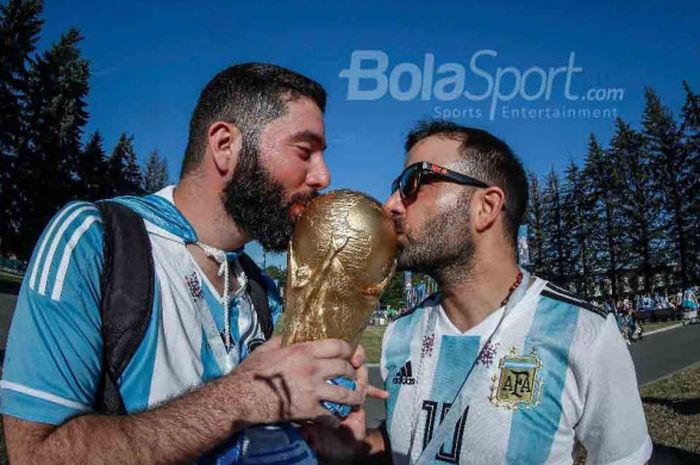  Dua fans timnas Argentina mencium replika trofi Piala Dunia sebelum menyaksikan laga Argentina kontra timnas Nigeria di Stadion Saint Petersburg, Selasa (26/6/2018). 