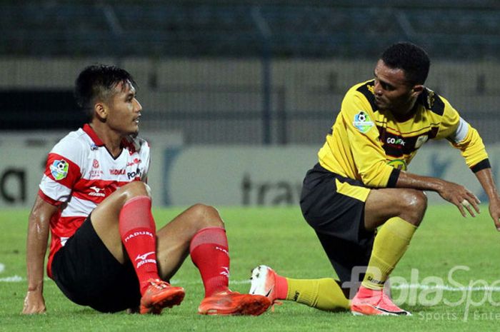 Ekspresi Guntur Ariyadi (Madura United) dan Rizki Pora (Barito Putera) dalam pertandingan.