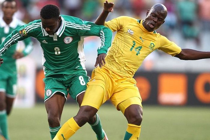 Pemain Afrika Selatan, Hlompho Kekana (kanan), berduel dengan Rabiu Ali dari Nigeria dalam duel Piala Afrika 2014 di Cape Town, 19 Januari 2014.