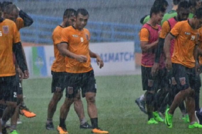 Para pemain Borneo FC berlatih di tengah guyuran hujan.