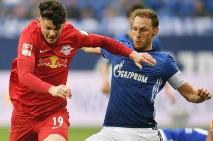 Kapten Schalke, Benedikt Hoewedes (kanan), mencoba menghentikan pergerakan pemain RB Leipzig, Oliver Burke, dalam partai Liga Jerman di Arena Aufschalke, Gelsenkirchen, 23 April 2017.