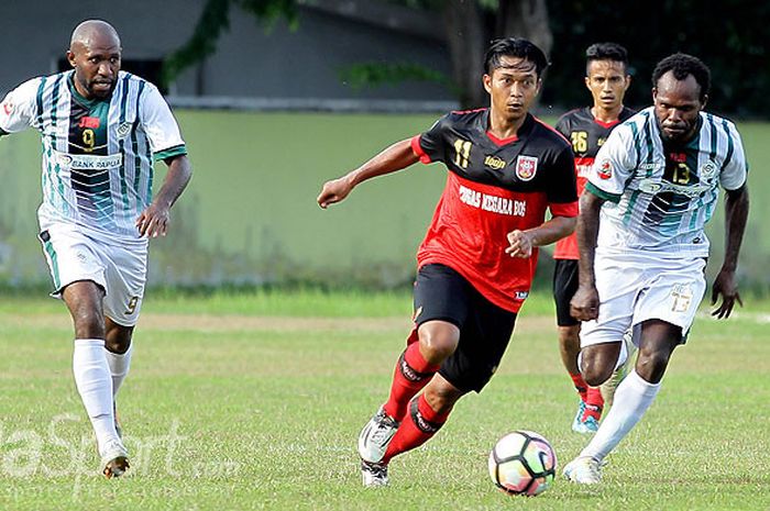 Pemain PS Mojokerto Putera, Indra Setiawan (tengah), menggiring bola dibayangi pemain Persiwa Wamena dalam laga putaran pertama babak 16 besar Liga 2 di Lapangan Kobangdikal Surabaya, Jawa Timur, Minggu (01/09/2017) sore.