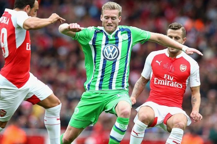 Gelandang Wolfsburg, Andre Schurrle (tengah), menggiring bola melewati dua pemain Arsenal dalam pertandingan Emirates Cup di Stadion Emirates, London, Inggris, pada 22 Juli 2015.