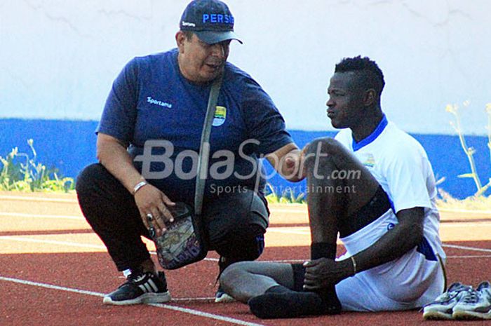 Dokter tim Persib, Rafi Ghani berbicang-bincang dengan Ezechiel N'Douassel seusai latihan di Stadion