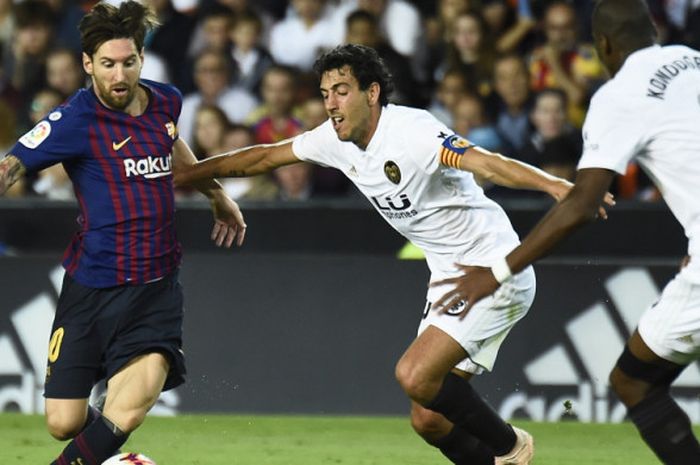 Aksi penyerang Barcelona, Lionel Messi (kiri), saat berduel dengan gelandang Valencia, Dani Parejo, dalam pertandingan Liga Spanyol 2018-2019 di Stadion Mestalla, Valencia, Spanyol, pada Minggu (7/10/2018).