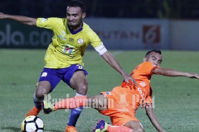 Pemain Barito Putera, Rizky Pora, diadang pemain Persija Jakarta, Riko Simanjuntak, pada laga pekan ke-11 Liga 1 2018 di Stadion 17 Mei, Banjarmasin, Rabu (30/5/2018).