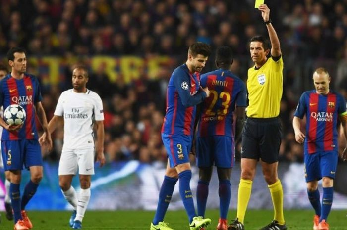 Bek FC Barcelona, Gerard Pique, mendapat kartu kuning dari wasit Deniz Aytekin pada laga Babak 16 Besar Liga Champions antara FC Barcelona dan Paris St Germain di Camp Nou pada 8 Maret 2017.