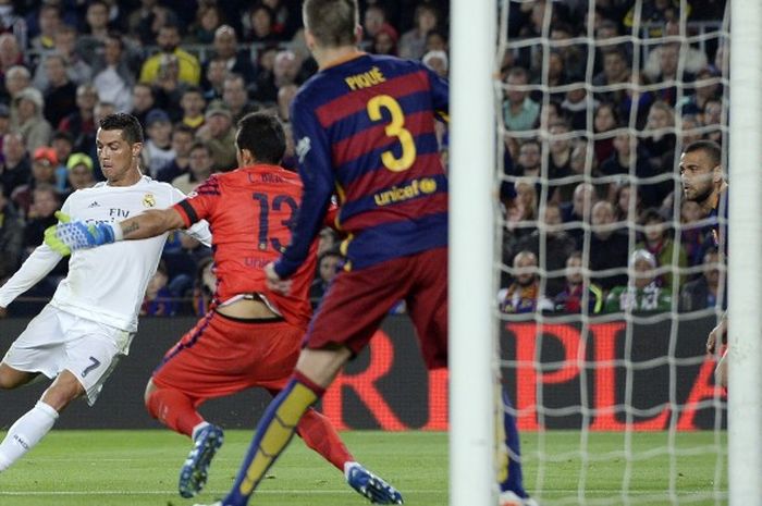Penyerang Real Madrid, Cristiano Ronaldo (kiri), melepaskan tembakan yang tak mampu dihalau kiper Barcelona asal Cile, Claudio Bravo, untuk mencetak gol dan membawa Madrid menang 2-1 pada el clasico dalam lanjutan La Liga di Camp Nou, Sabtu (2/4/2016).