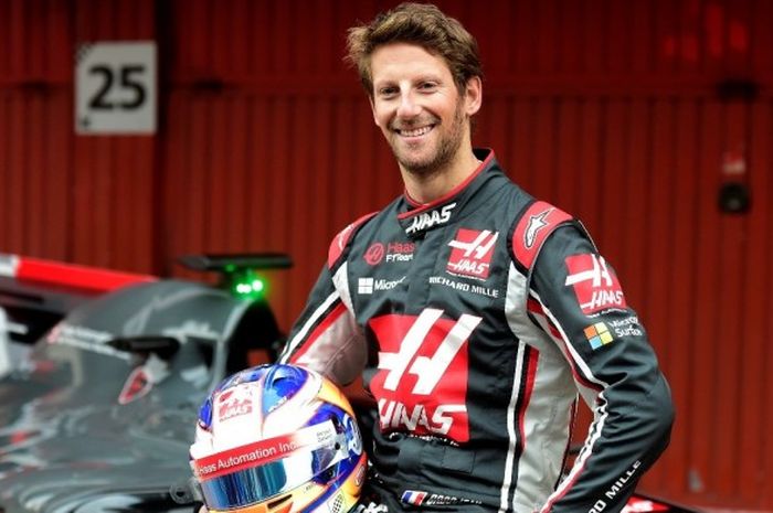 Pebalap Formula 1 (F1) yang membela tim Haas, Romain Grosjean, berpose bersama mobil untuk musim balap 2017, VF17, pada presentasi resmi yang digelar di Sirkuit De Barcelona-Catalunya, 27 Februari lalu.