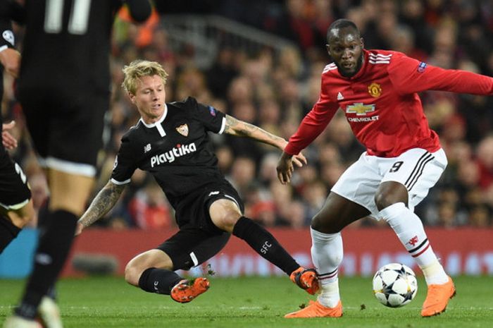 Striker Manchester United, Romelu Lukaku (kanan), menguasai bola dari incaran bek Sevilla, Simon Kjaer (tengah), dalam laga leg 2 babak 16 besar Liga Champions 2017-2018 di Stadion Old Trafford, Manchester, Inggris, pada 13 Maret 2018.