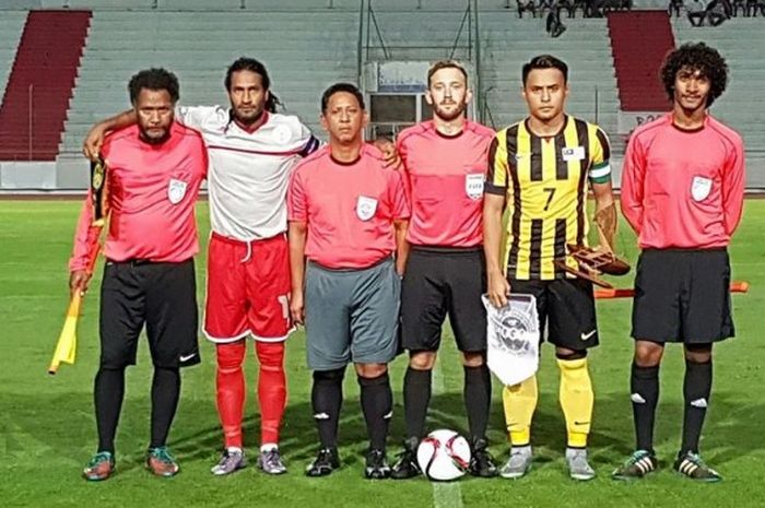 Kapten timnas Kaledonia Baru, Betrand Kai (dua dari kiri) dan kapten timnas Malaysia, Aidil Zafuan (dua dari kanan) berpose bersama perangkat pertandingan kedua negara sebelum laga persahabatan di Stadion Numa-Daly Magenta, Noumea, Rabu (22/6/2016). 