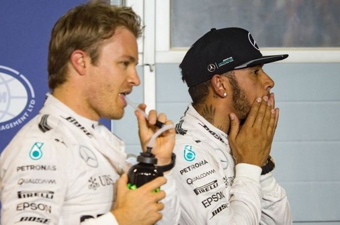 Pebalap Mercedes, Nico Rosberg (kiri) dan Lewis Hamilton, menunggu setelah menyelesaikan sesi kualifikasi GP Bahrain di Sirkuit Internasional Bahrain, Sabtu (2/4/2016).