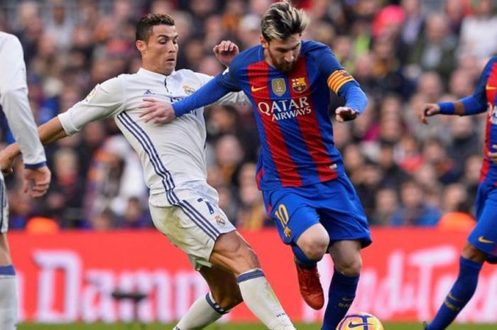     Bintang FC Barcelona dan Real Madrid, Lionel Messi (kanan) dan Cristiano Ronaldo, berduel dalam laga Liga Spanyol di Camp Nou pada Sabtu (3/12/2016).    