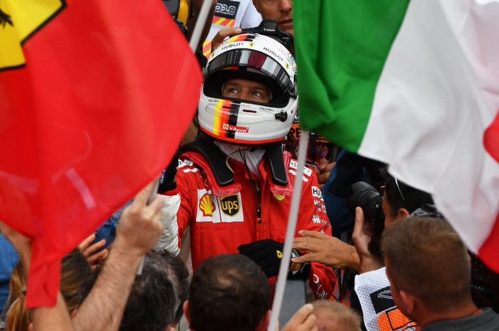 Sebastian Vettel merayakan kemenangannya bersama fan Ferrari.