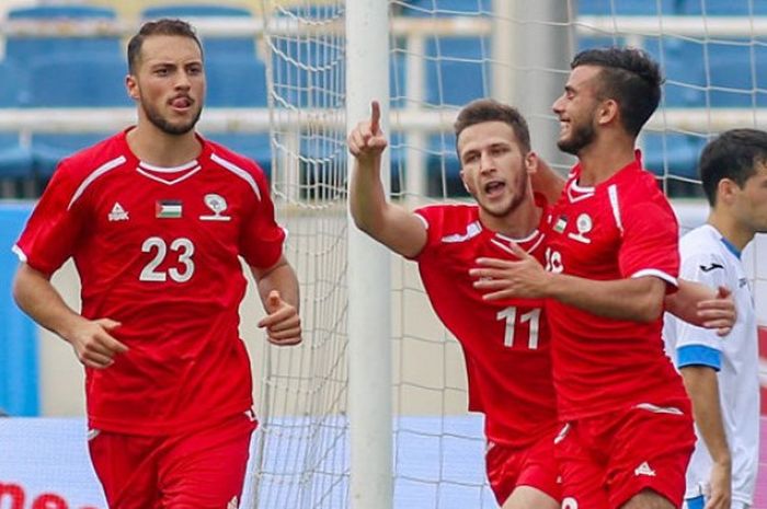   Tiga pemain timnas U-23 Palestina merayakan gol ke gawang timnas U-23 Uzbekistan pada pertandingan kedua turnamen Vinaphone Cup 2018 di Stadion Nasional My Dihn, Hanoi, 5 Agustus 2018.  