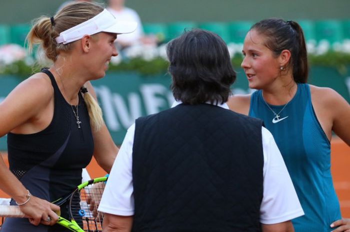 Caroline Wozniacki (kiri) dan Daria Kasatkina (kanan) berunding dengan umpire (tengah) karena laga 16 besar Roland Garros 2018  yang tengah mereka jalani terpaksa ditunda, Mingu (3/6/2018).