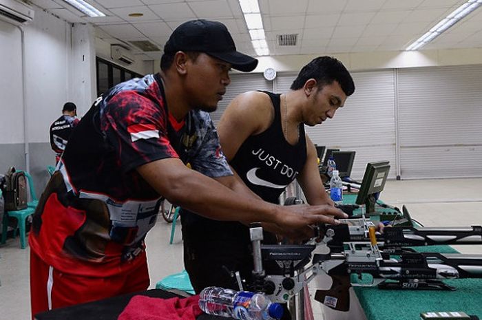 Pelatih tim para shooting Indonesia, Saridi (memakai topi) sedang mempersiapkan peralatan pada latihan di lapangan tembak Senayan, Jakarta, Jumat (22/9/2018).