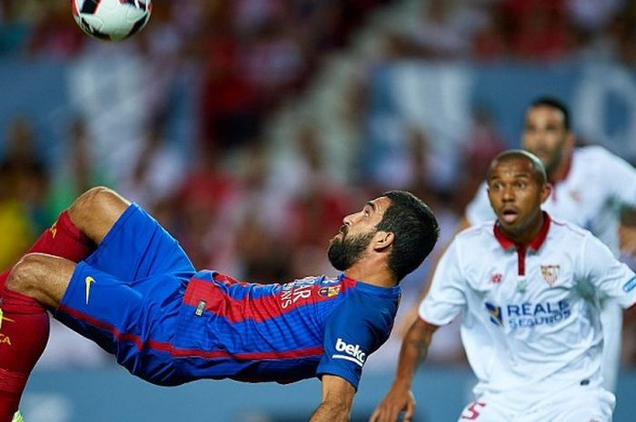 Aksi gelandang Barcelona, Arda Turan (kiri), saat melakukan tembakan akrobatik dalam laga Piala Super Spanyol lawan Sevilla di Ramos Sanchez Pizjuan, 14 Agustus 2016.