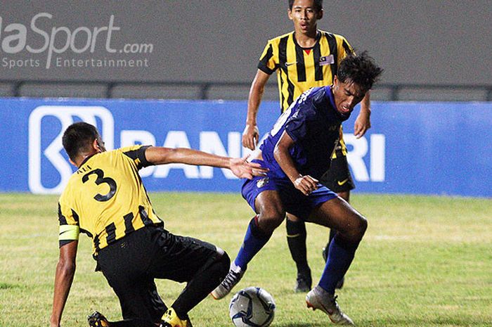 Pemain Thailand U-16 (biru) berusaha lepas dari kawalan dua pemain Malaysia U-16 di Stadion Gelora Joko Samudro Gresik, Senin (30/7/2018).