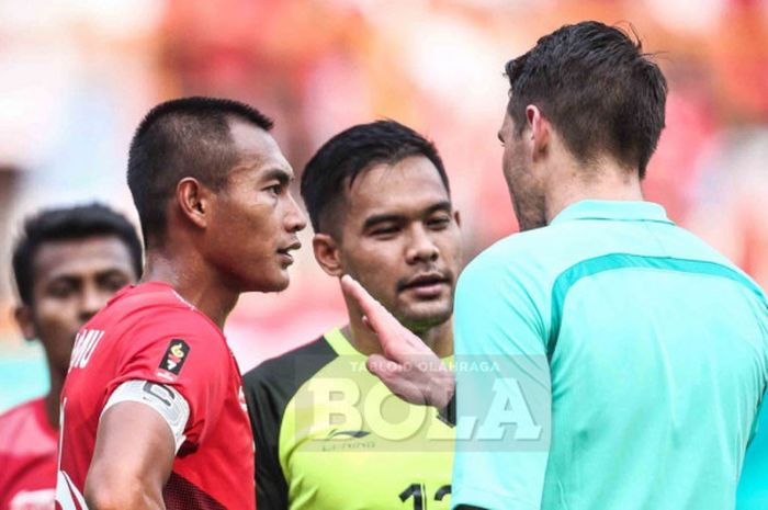   Kapten tim nasional U-23 Indonesia, Hansamu Yama, berdiskusi dengan wasit Shaun Evans dalam pertandingan babak 16 besar sepak bola Asian Games 2018 di Stadion Wibawa Mukti, Jumat (24/8/2018).   