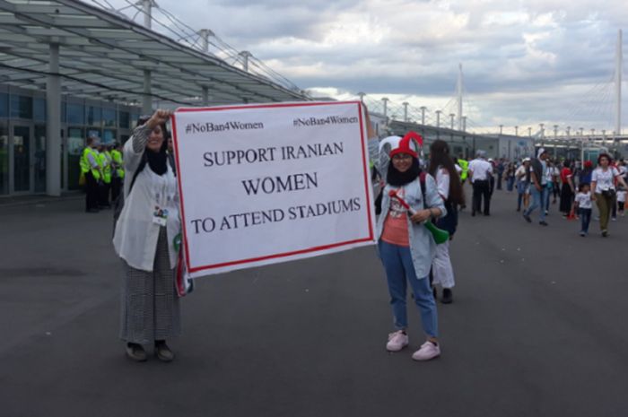 Suporter perempuan yang membentangkan spanduk berisi protes larangan perempuan Iran memasuki stadion saat pertandingan sepak bola di Iran.