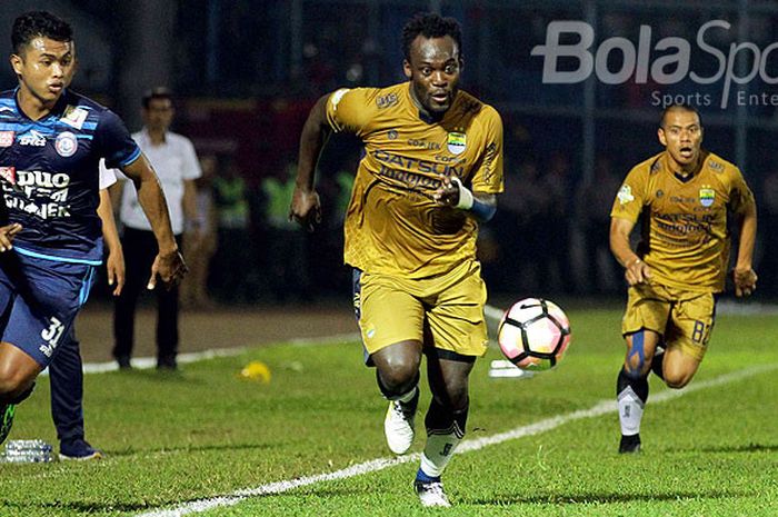Gelandang Persib Bandung, Michael Essien (tengah), menggiring bola dibayangi pemain Arema FC, Junda Irawan (kiri), saat kedua tim bertemu di laga pekan ke-19 Liga 1 di Stadion Kanjuruhan Malang, Jawa Timur, Sabtu (12/08/2017) malam.