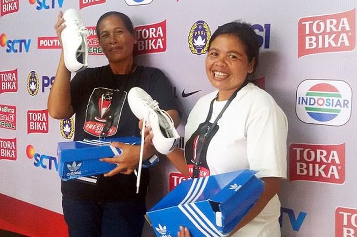 Ni Nyoman Srimin (kiri) dan Ni Nyoman Sumen (kanan) terlihat senyum sambil menunjukan sepatu baru  yang diberikan bek Bali United, Hasyim Kipuw.