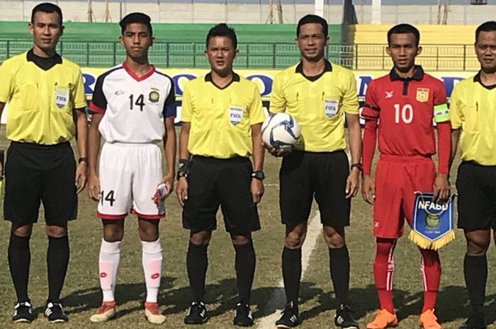 Kapten timnas U-16 Laos (merah) dan timnas U-16 Brunei (putih) berpose dengan perangkat pertandingan sebelum laga Grup A Piala AFF U-16 2018 di Stadion Gelora Joko Samudro, Kabupaten Gresik, 30 Juli 2018. 
