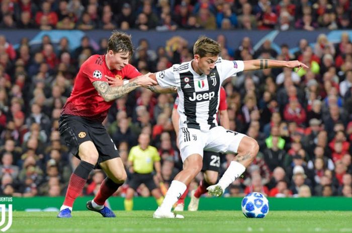 Striker Juventus, Paulo Dybala, berduel dengan bek Manchester United, Victor Lindelof, pada laga fase grup Liga Champions di Old Trafford, Selasa (23/10/2018) atau Rabu dini hari WIB