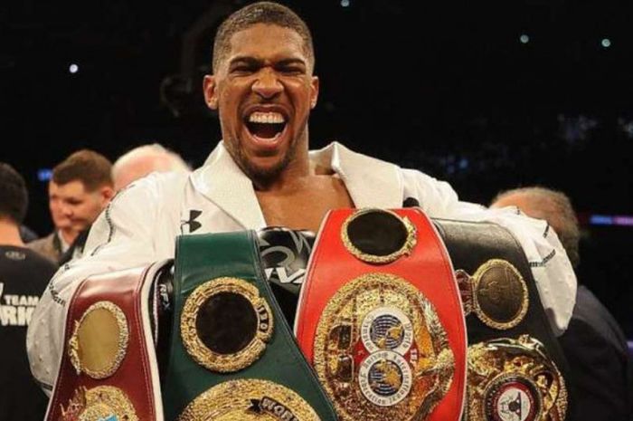 Petinju kelas berat asal Inggris, Anthony Joshua, berpose dengan empat sabuk juaranya.