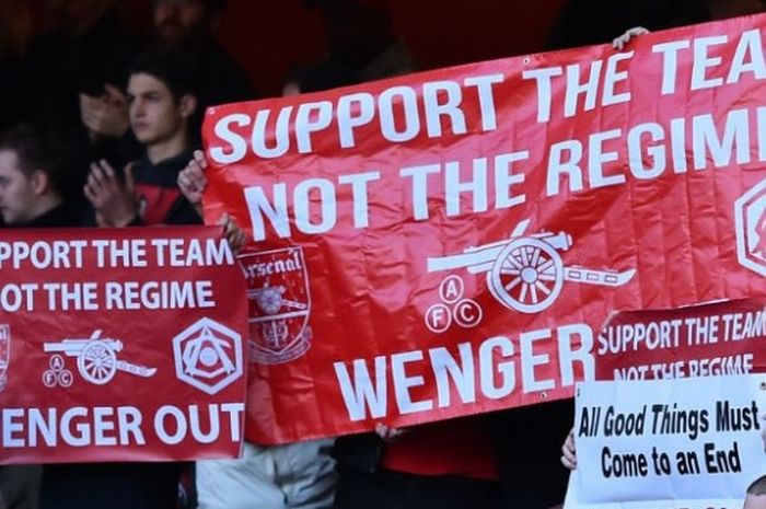 Sejumlah fans Arsenal mengacungkan poster yang meminta pelatih klub tersebut, Arsene Wenger mundur dari jabatannya, dalam laga melawan Norwich di Emirates Stadium, Sabtu (30/4/2016). 