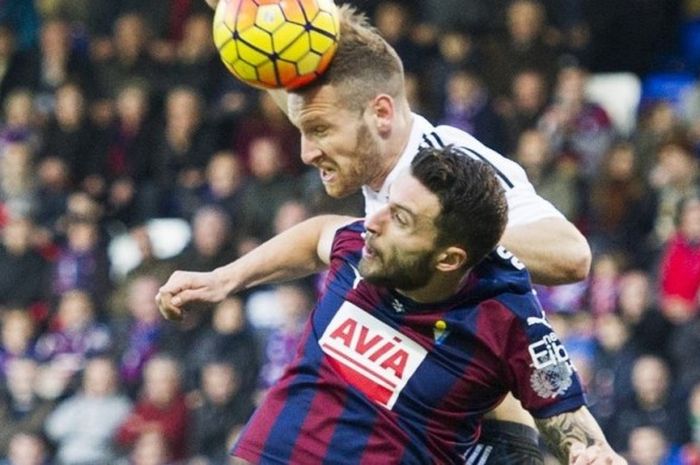 Striker Eibar, Borja Baston (bawah), berduel udara dengan bek Valencia, Shkodran Mustafi, para pertandingan La Liga 2015-2016 di Stadion Ipurua Municipal, Eibar, Spanyol, pada 13 Desember 2015.