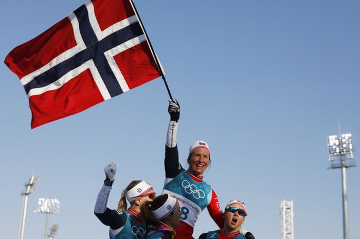 Atlet ski putri Norwegia, Marit Bjoergen, diangkat rekan-rekan senegaranya setelah berhasil memenangi laga final nomor cross country 30 kilometer, Minggu (25/2/2018). Melalui kemenangan Bjoergen, Norwegia keluar sebagai juara umum Olimpiade Musim Dingin Pyeongchang 2018.
