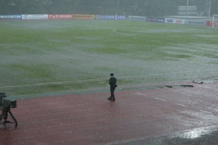 Petugas mengamati lapangan Stadion Nasional Bukit Jalil, Kuala Lumpur, Malaysia, yang tergenang air akibat hujan deras, Rabu (26/9/2018) sore WIB.